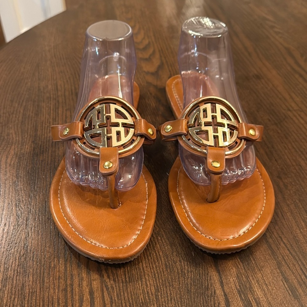 Tan Pierre Dumas limit style slip on sandal with gold emblem detail.